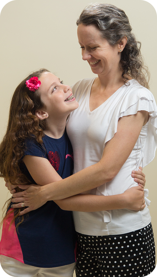 Mother And Daughter Wearing Braces Smiling At Each Other