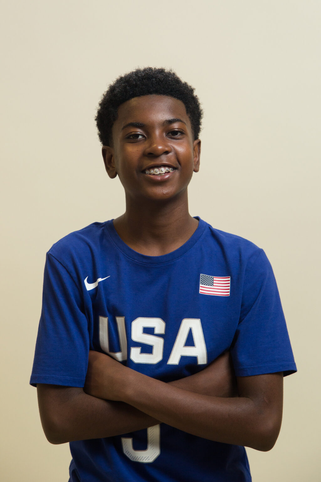 Smiling adolescent with braces in a royal blue team USA tee shirt