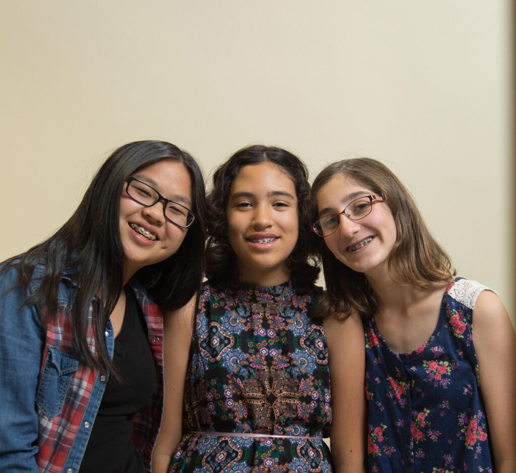 3 young girls with braces smiling together