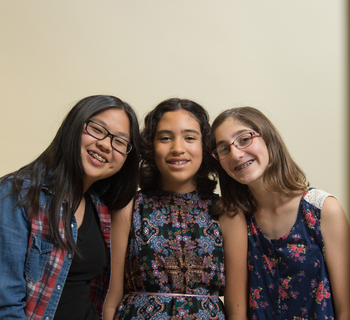 3 young girls with braces smiling together