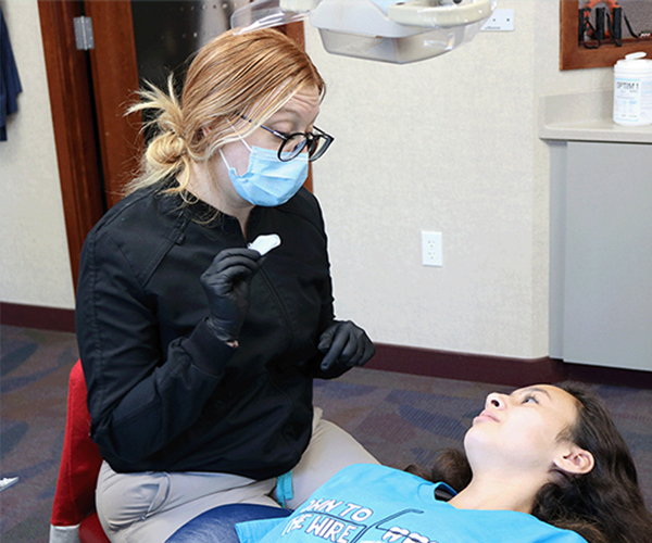 Sheffield & Le orthodontic technician consulting with a patient during an exam