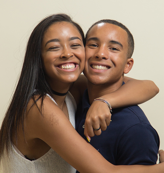 Brother and sister smiling while smushed together in a hug at Sheffield & Le orthodontics