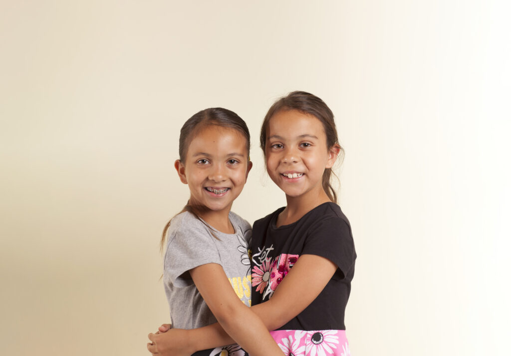 Two young girls smiling after receiving treatment at Sheffield and Le Orthodontics