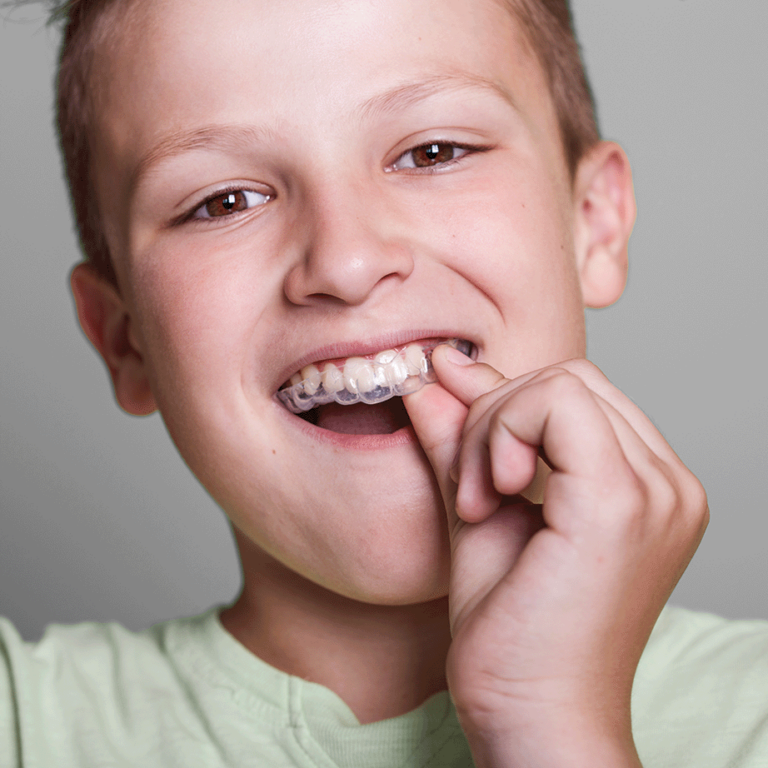 Portrait Of A Kid With Clear Aligners