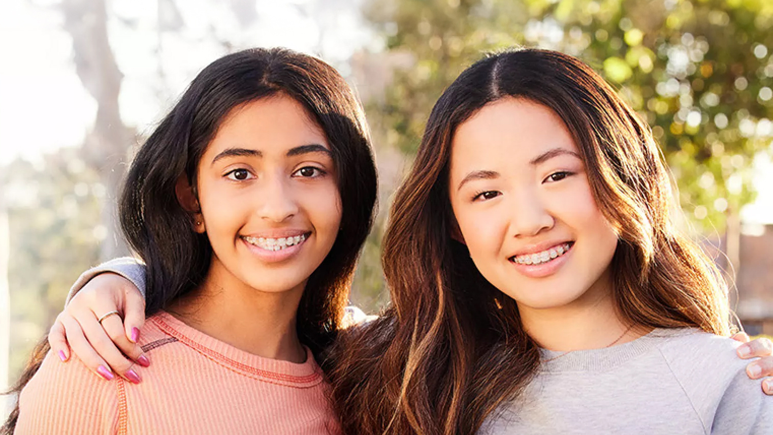 Two Teenagers Standing Outside Wearing Clear Braces