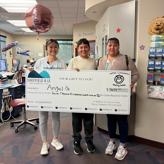 Dr Le Handing Over A Check For School Sponsorships